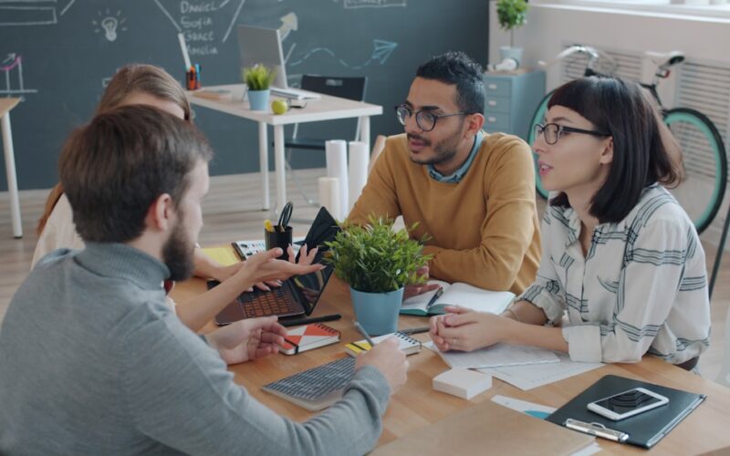 Diverse team collaborating around a table in office.