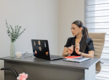 Woman working on a laptop at a desk.