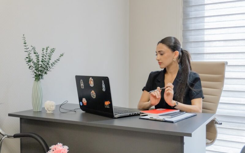 Woman working on a laptop at a desk.
