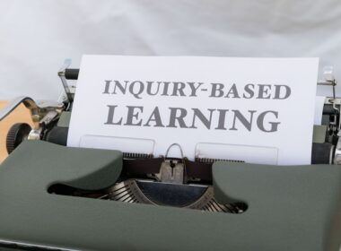 a close up of a typewriter with an inquiry - based learning sign