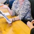 woman holding tablet computer showing to seatmate