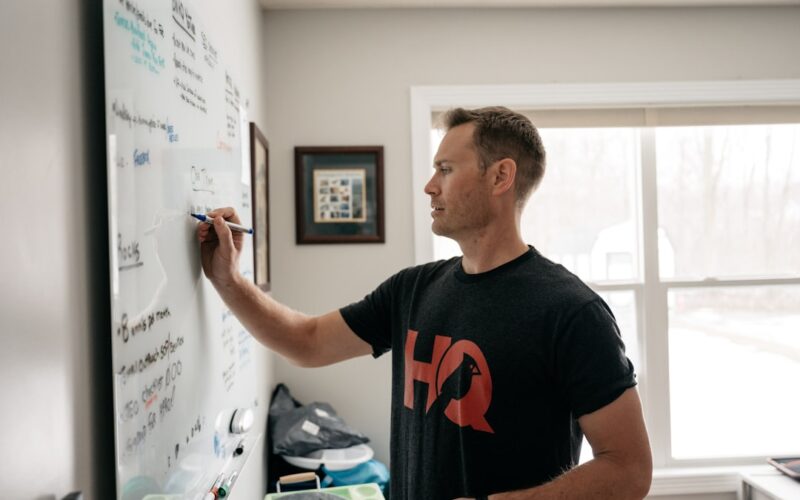 a man writing on a white board