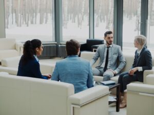 Four professionals in a modern office meeting space.