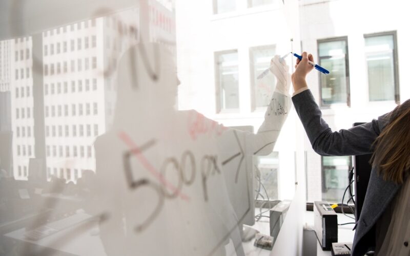 person writing on whiteboard