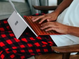 Person in checkered pajamas on their Surface laptop at home