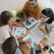 Four people collaborating around a table with documents.