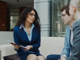 Three professionals in a business meeting discussion
