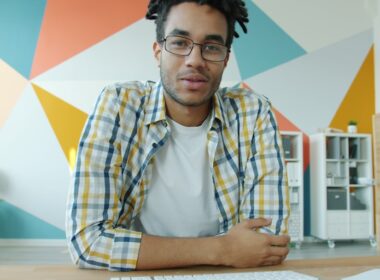 Man with dreadlocks talking on video call