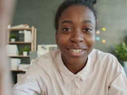 Young woman smiles at the camera in an office setting.