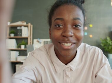 Young woman smiles at the camera in an office setting.