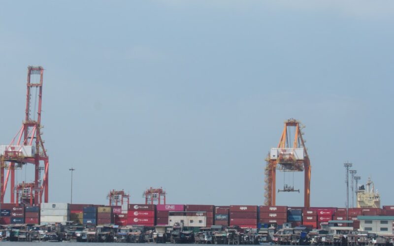 Shipping containers and cranes at a busy port.