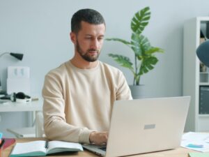 Man working on a laptop at a desk.