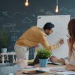 Man presenting ideas on whiteboard to colleagues