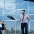 Man celebrating success outside modern office building