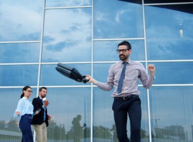 Man celebrating success outside modern office building