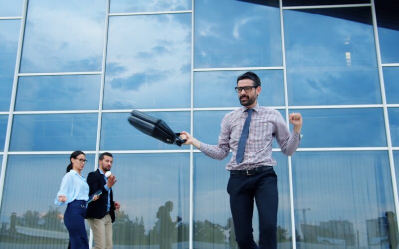 Man celebrating success outside modern office building