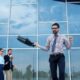 Man celebrating success outside modern office building